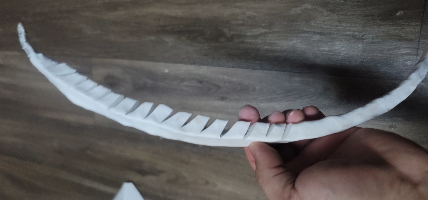 polymer clay formed around an old s-video cable. cut niches out of the sides and freed the links to let it flex